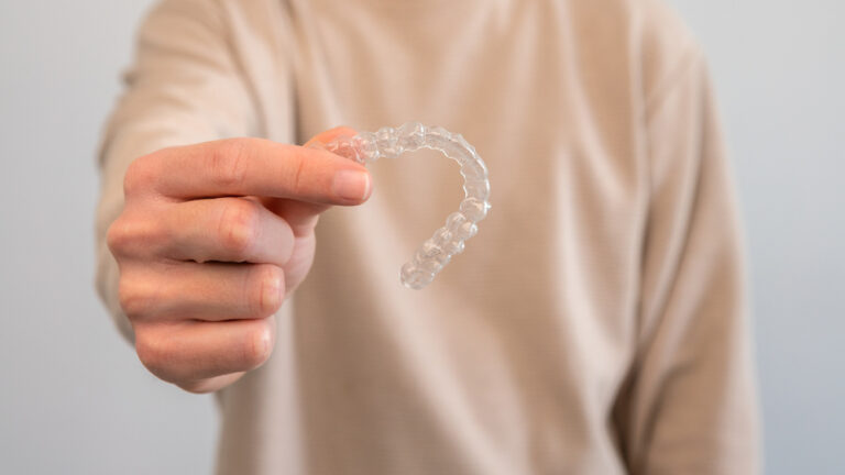 man holds invisalign transparent braces for dental 2022 10 06 16 13 57 utc 1